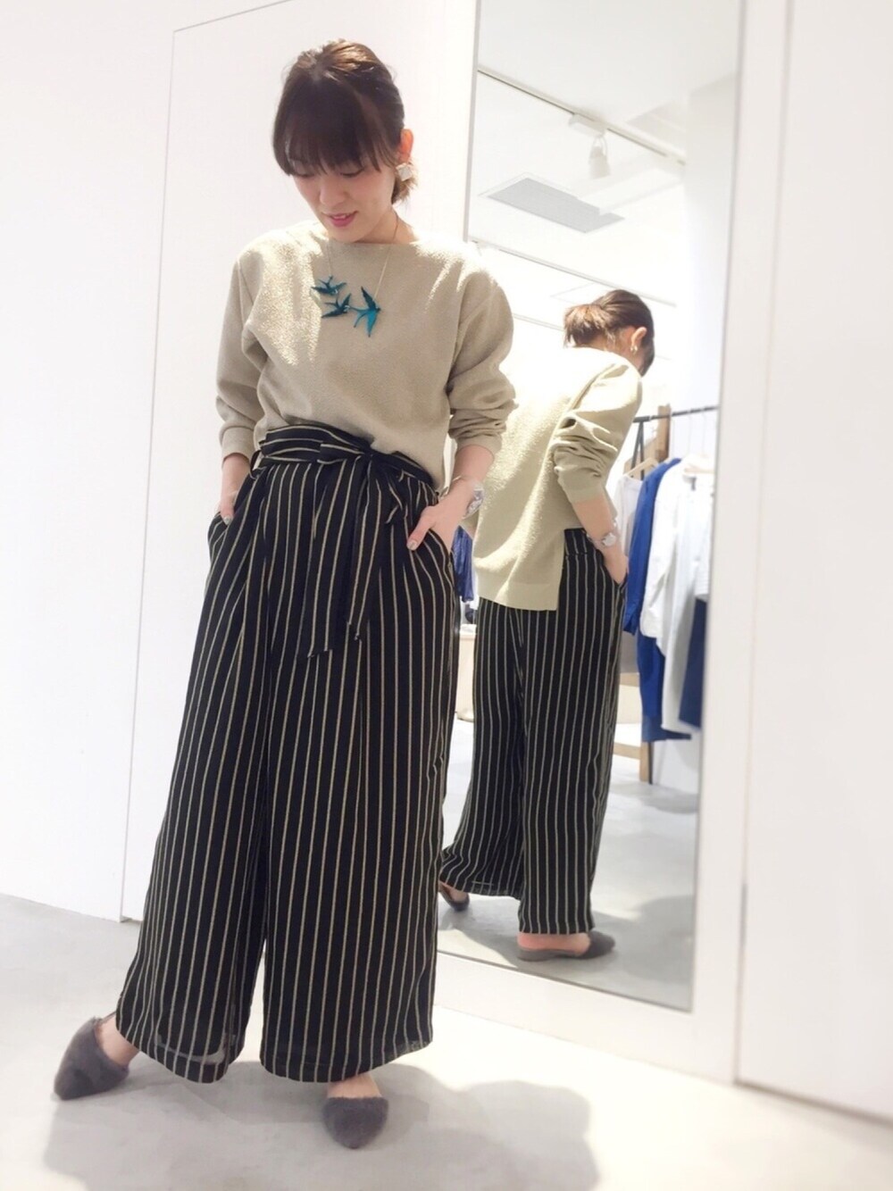 ゴールド系のニット/セーター、ブラック系のその他パンツ、その他のネックレスを着用したレディースの春コーディネートの1枚目の写真