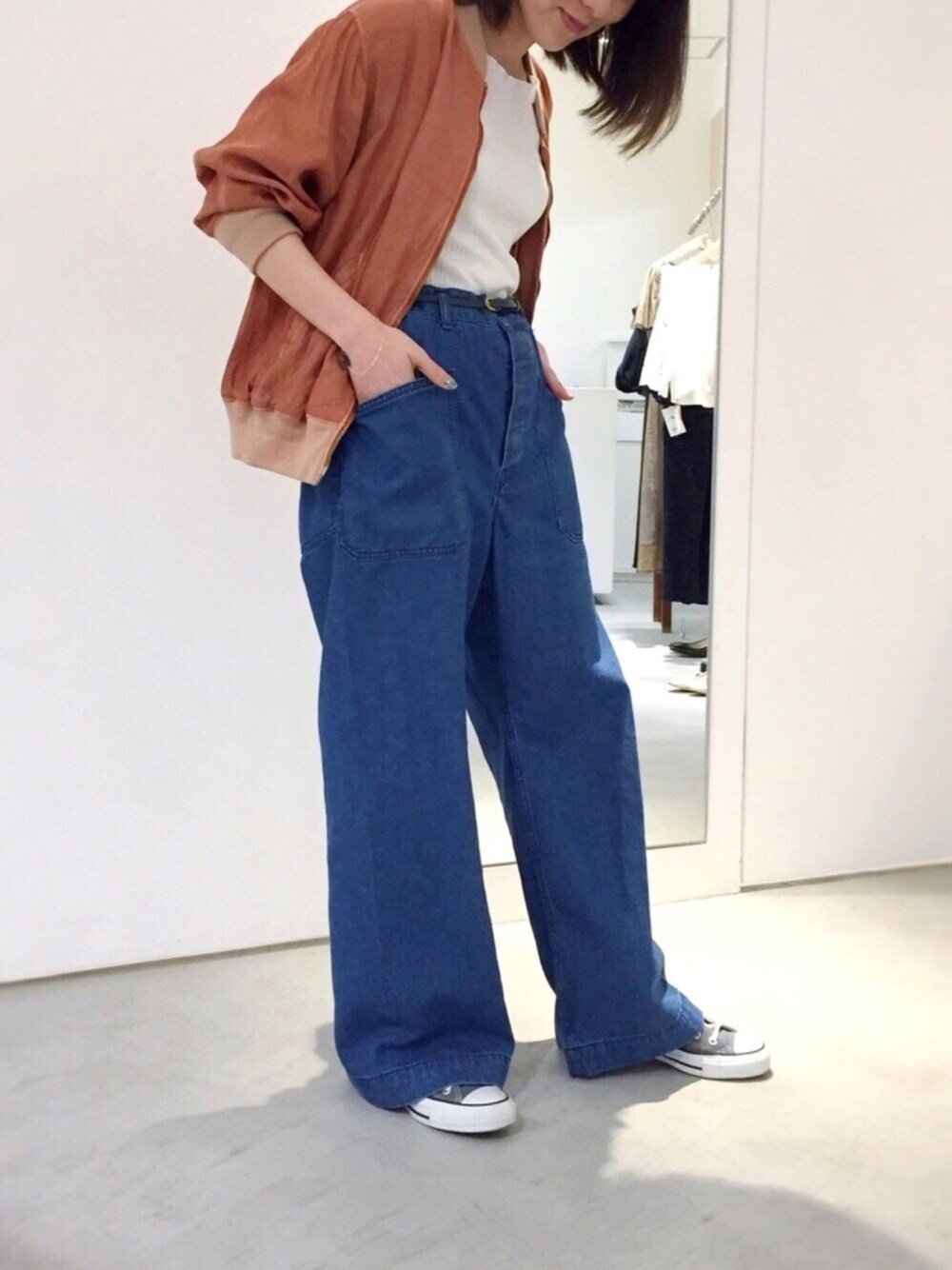 ブルー系のデニムパンツ、ホワイト系のTシャツ/カットソー、ブラウン系のMA-1を着用したレディースの春コーディネートの1枚目の写真