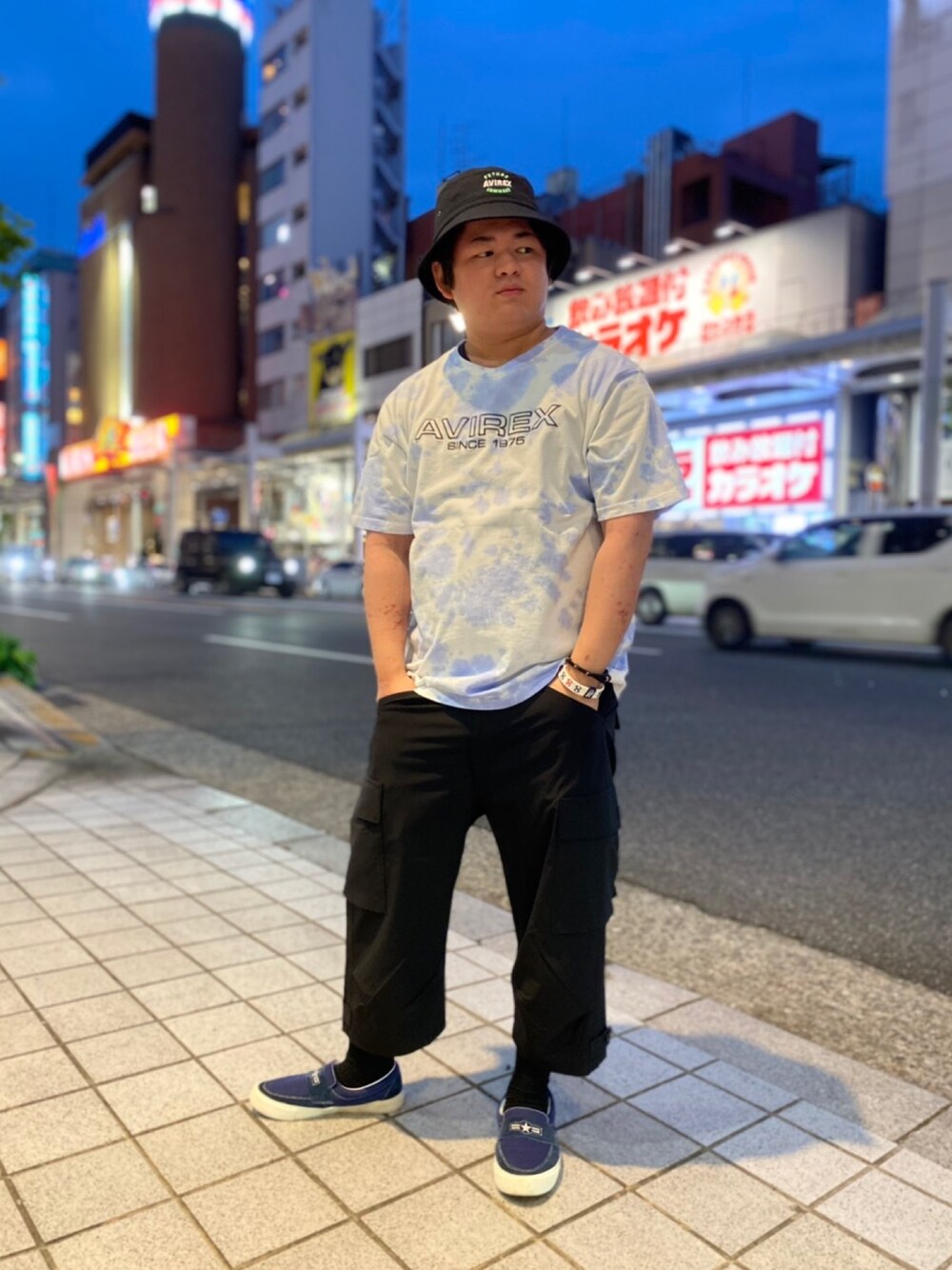 「ミリタリー、AVIREX、タイダイ柄、カーゴパンツ、スリッポン、休日コーデ、バケットハット、coordinate、おしゃれさんと繋がりたい、はるコーデ」｜「AVIREXのファジー タイダイ ロゴ Tシャツ / SS FUZZY TIE DYE LOGO T-SHIRT / アヴィレックス / AVIREX（Tシャツ/カットソー、パープル系）」を使った、TETTAさん（メンズ・166cm）の春コーディネートの1枚目の写真