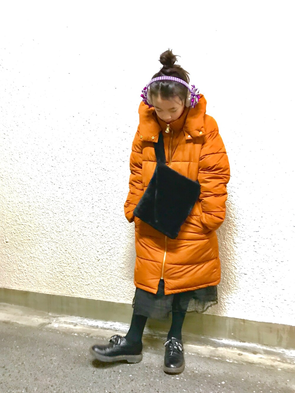 ブラック系のスカート、パープル系のイヤーマフを着用したキッズの冬コーディネートの1枚目の写真