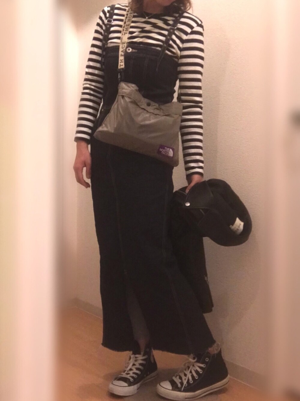 ブラック系のライダースジャケット、ブルー系のワンピース、ブラック系のスニーカーを着用したレディースの春コーディネートの1枚目の写真