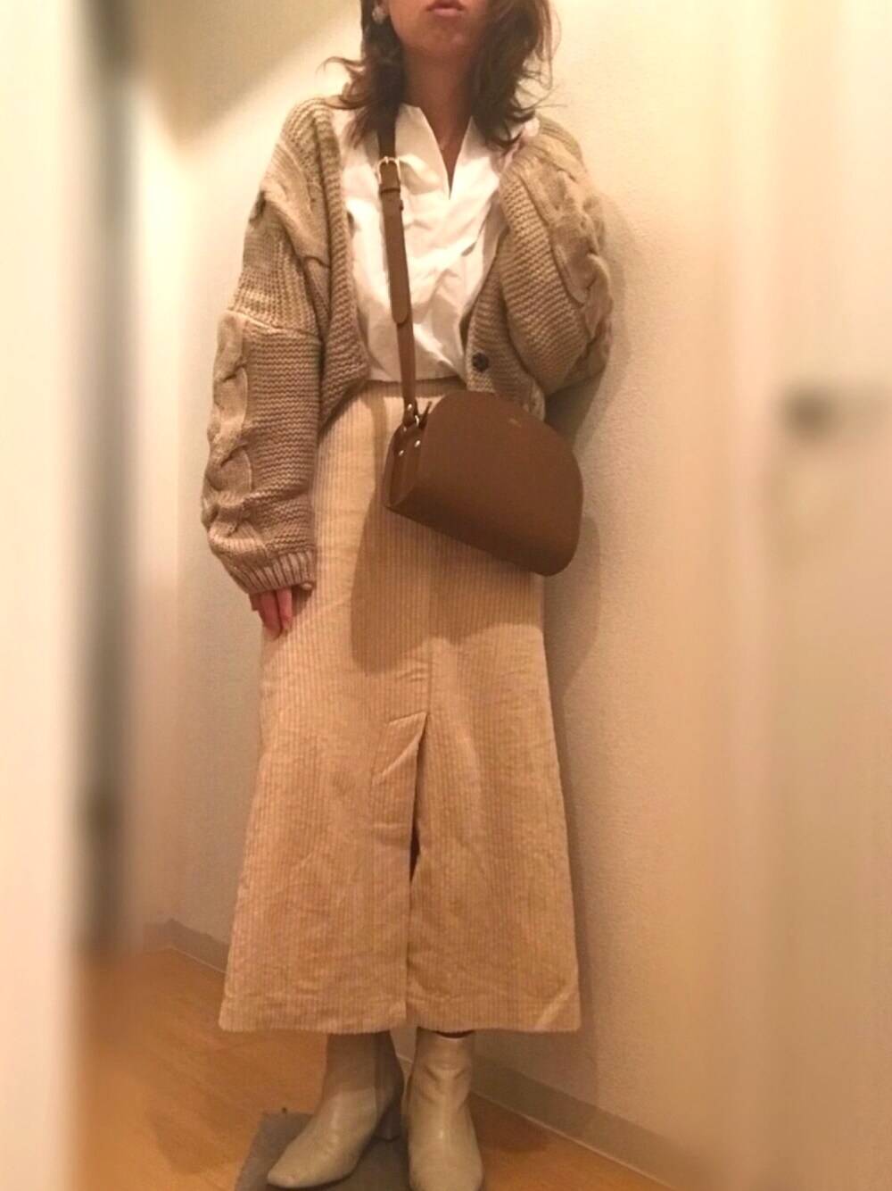 ベージュ系のカーディガン/ボレロ、ホワイト系のシャツ/ブラウス、ベージュ系のスカートを着用したレディースの春コーディネートの1枚目の写真