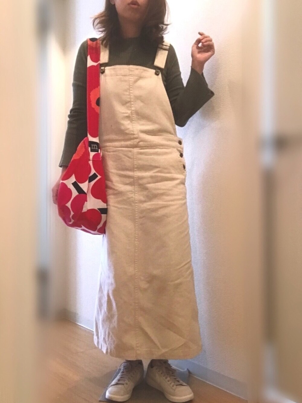 グリーン系のTシャツ/カットソー、ベージュ系のスニーカー、レッド系のバッグを着用したレディースの春コーディネートの1枚目の写真