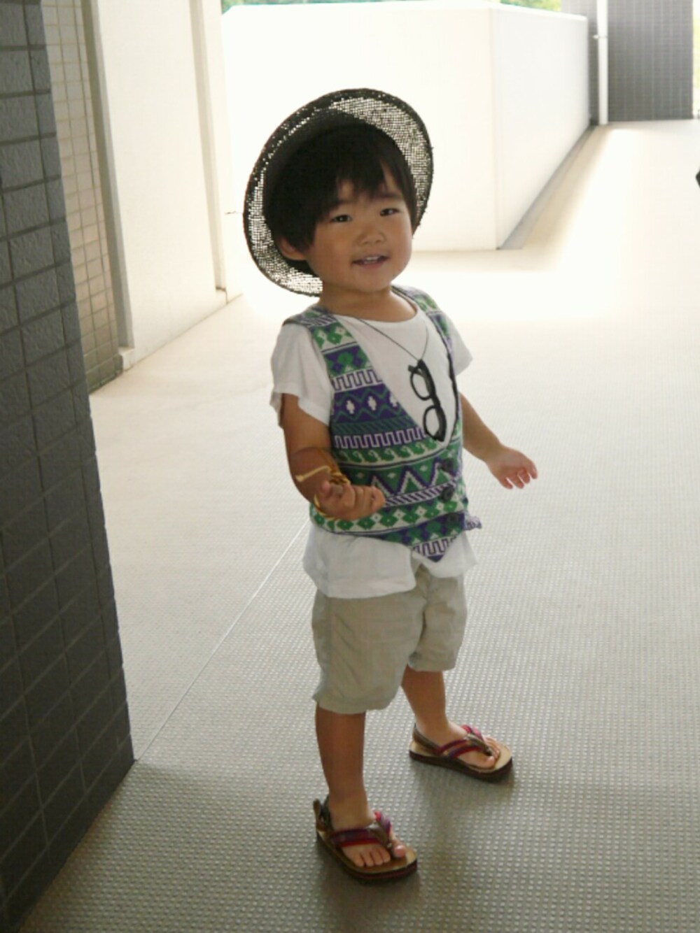 「グリーンフェス❹、シンプル、キッズコーデ、夏、サンダル、ハーフパンツ、ベスト、だまし絵Tシャツ、柄ベスト、ビーチサンダル」｜「kidsforetのアイテム（ハット、ブラック系）」を使った、*そうまりこ*さん（キッズ・90cm）の夏コーディネートの1枚目の写真