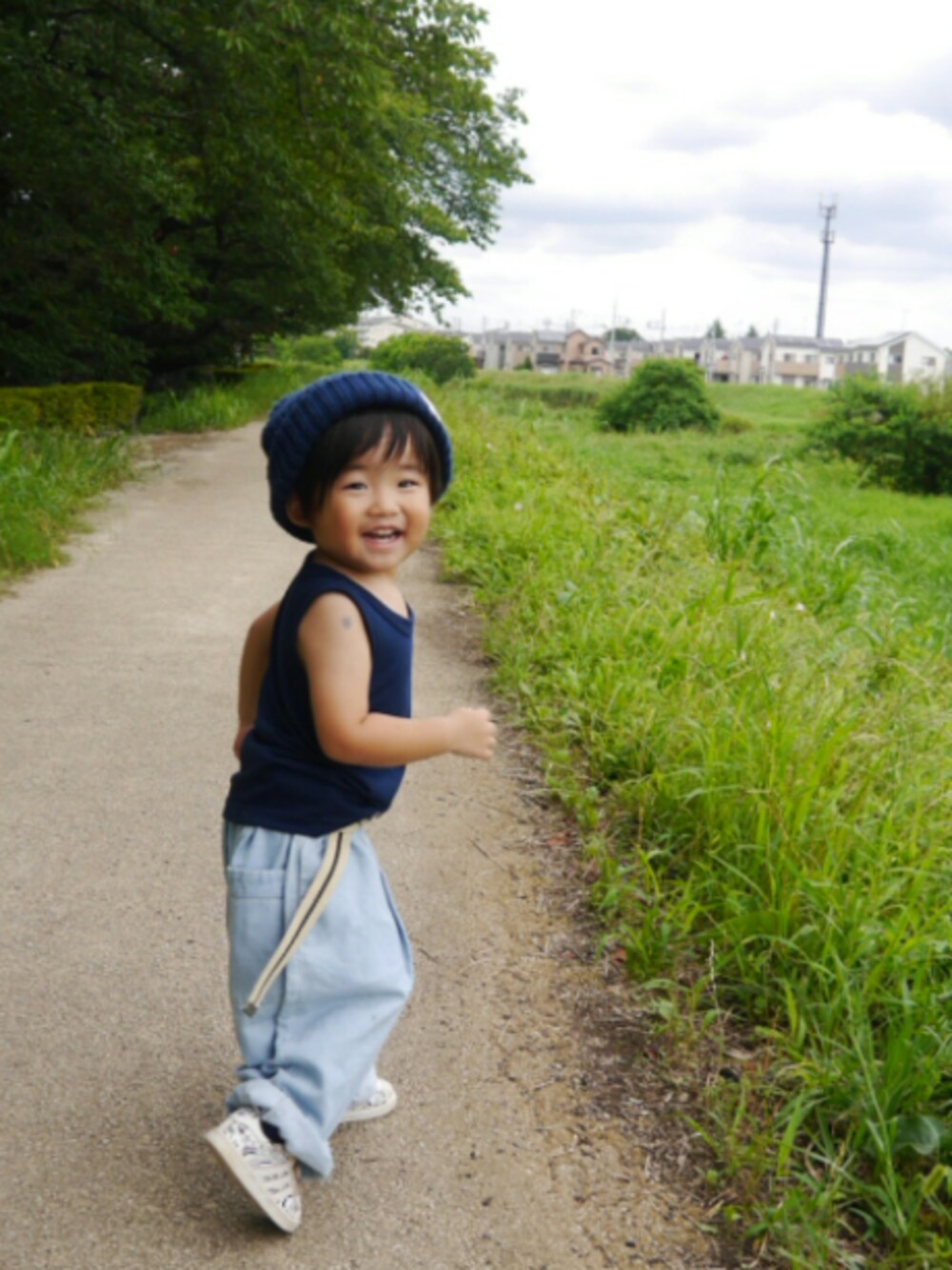 ブルー系のタンクトップ、ブルー系のデニムパンツ、ホワイト系のスニーカーを着用したキッズの夏コーディネートの1枚目の写真