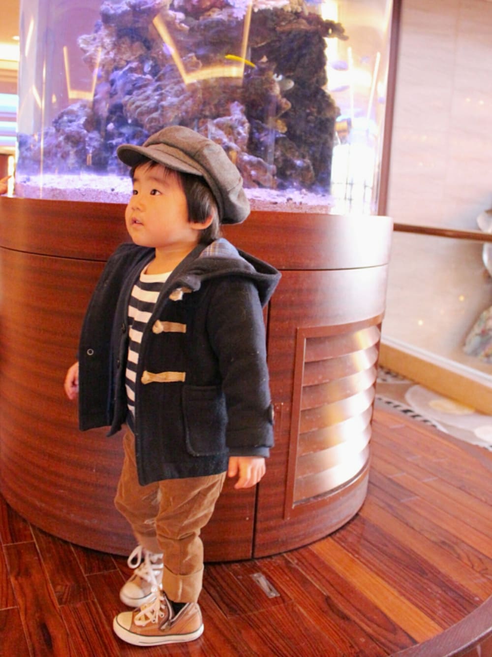 ブルー系のダッフルコート、ブルー系のカーディガン/ボレロ、ホワイト系のTシャツ/カットソーを着用したキッズの冬コーディネートの1枚目の写真