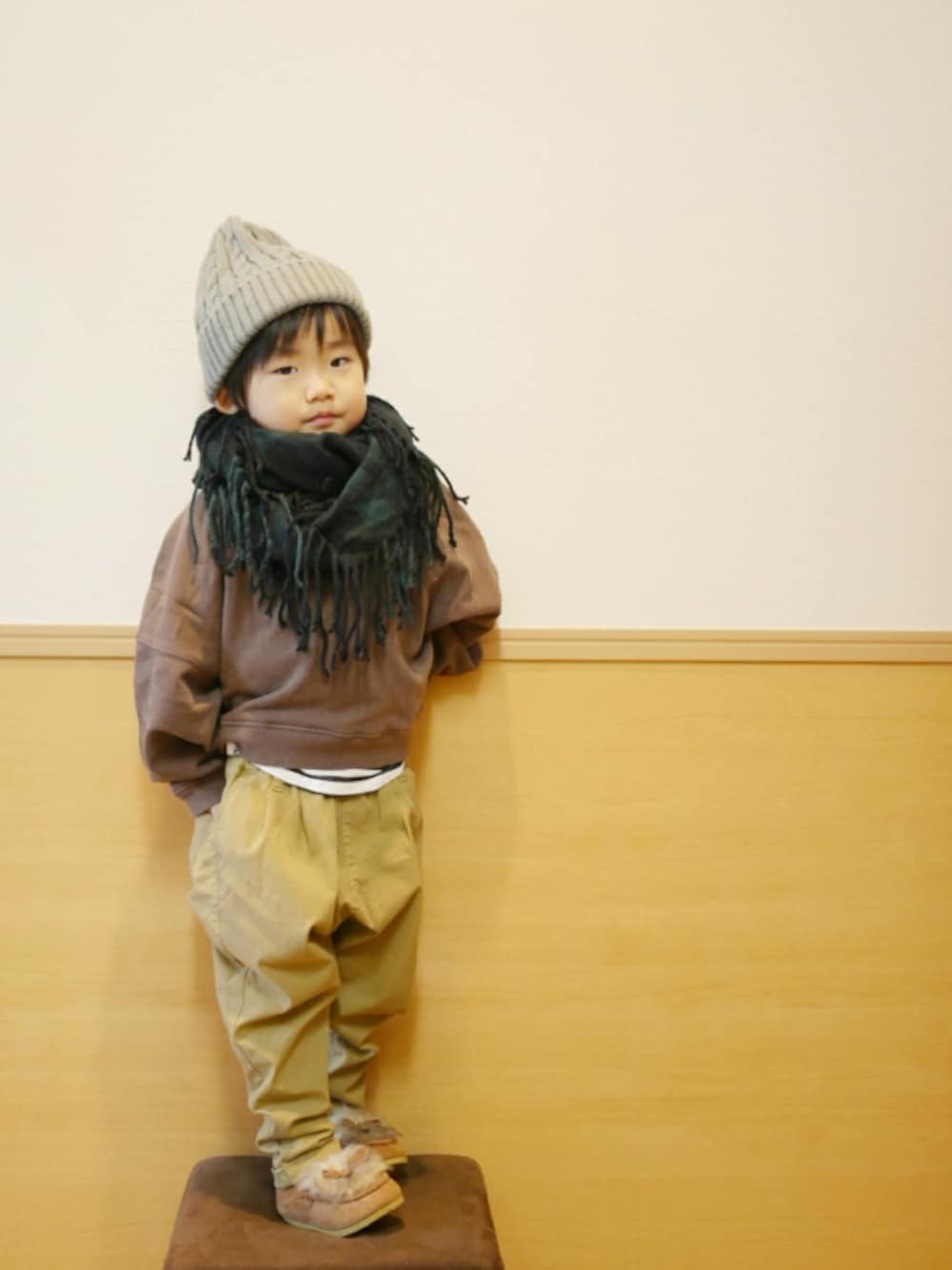 ブラウン系のスウェット、ホワイト系のタンクトップ、ベージュ系のその他パンツを着用したキッズの冬コーディネートの1枚目の写真