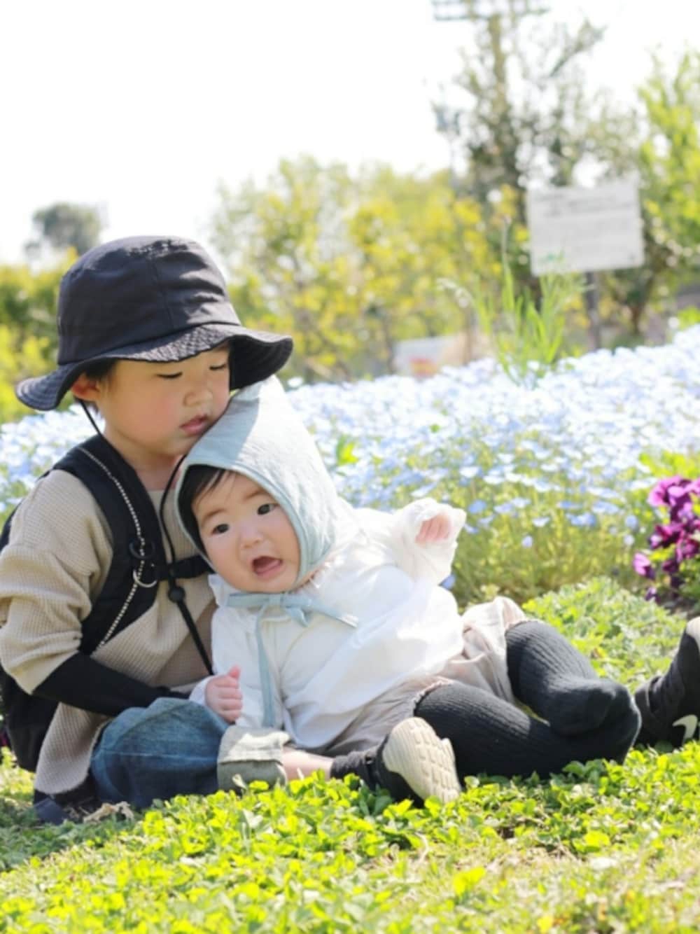 ベージュ系のTシャツ/カットソー、ブラック系のスニーカー、その他のラッピングキットを着用したキッズの春コーディネートの1枚目の写真