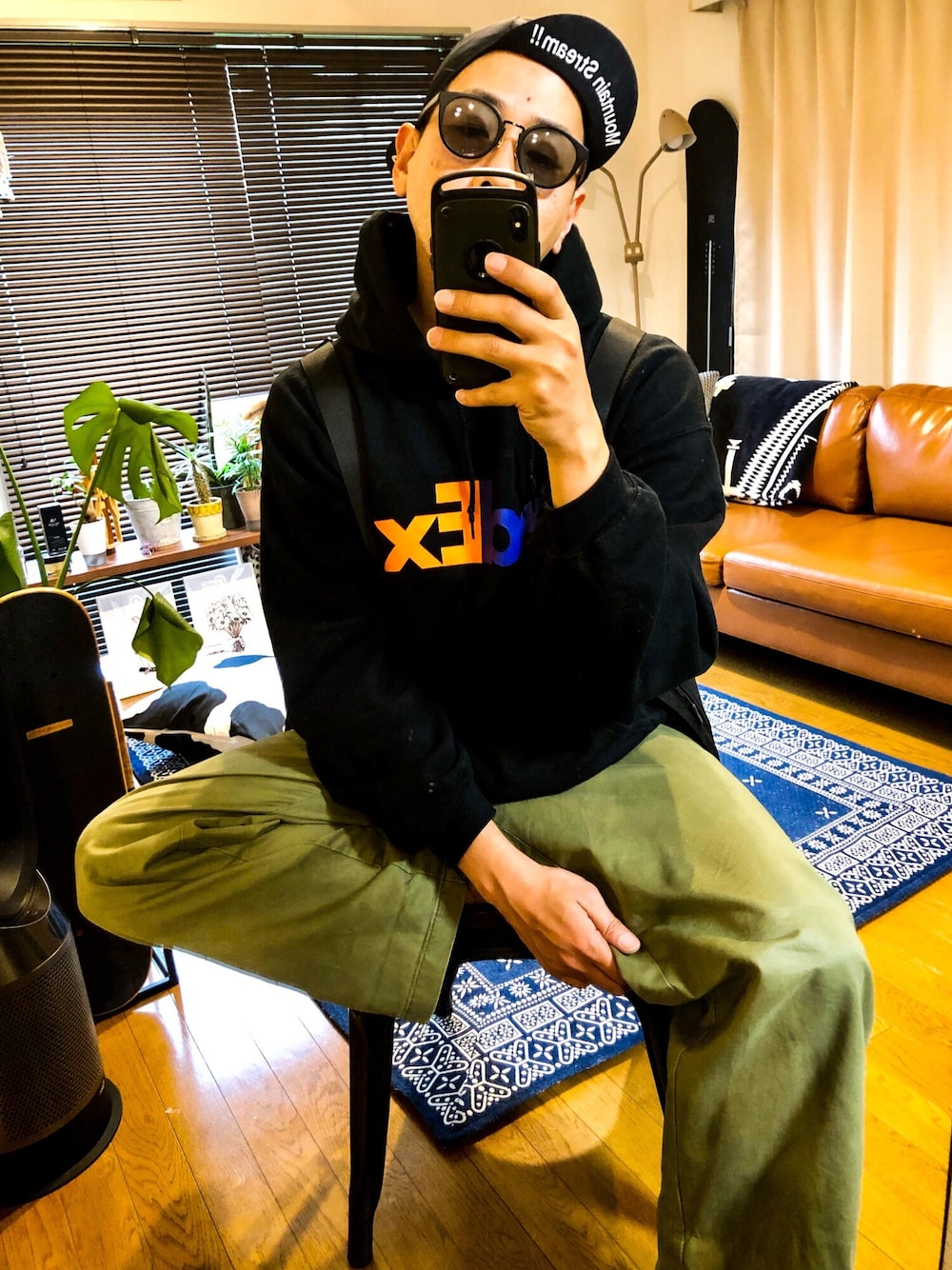 ブラック系のベスト、ブラック系のパーカー、グリーン系のチノパンツを着用したメンズの春コーディネートの1枚目の写真