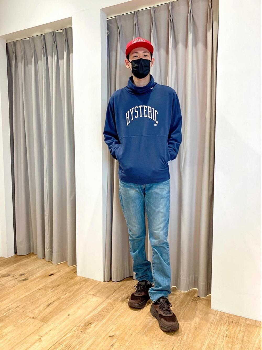 ブルー系のスウェット、ブルー系のデニムパンツ、レッド系のキャップを着用したメンズの秋コーディネートの1枚目の写真