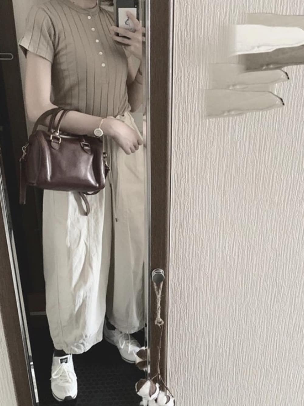 ベージュ系のTシャツ/カットソー、ブラウン系のショルダーバッグ、ホワイト系のスニーカーを着用したレディースの夏コーディネートの1枚目の写真