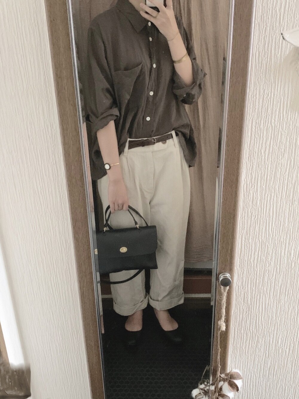 ブルー系のショルダーバッグ、ブラック系のバレエシューズ、その他のアナログ腕時計を着用したレディースの秋コーディネートの1枚目の写真