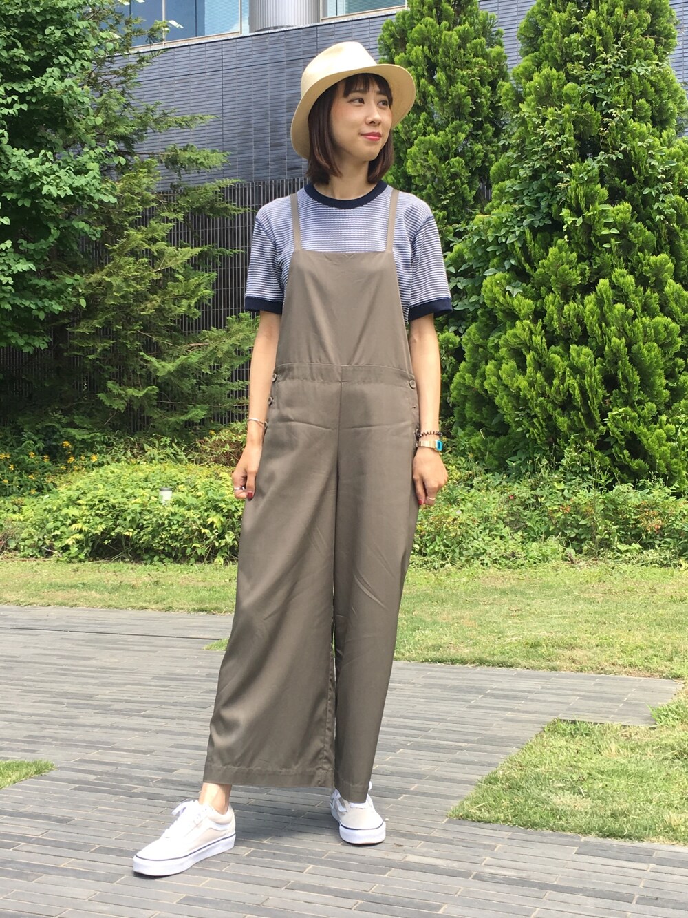 グリーン系のサロペット/オーバーオール、ブルー系のTシャツ/カットソー、ベージュ系のスニーカーを着用したレディースの夏コーディネートの1枚目の写真