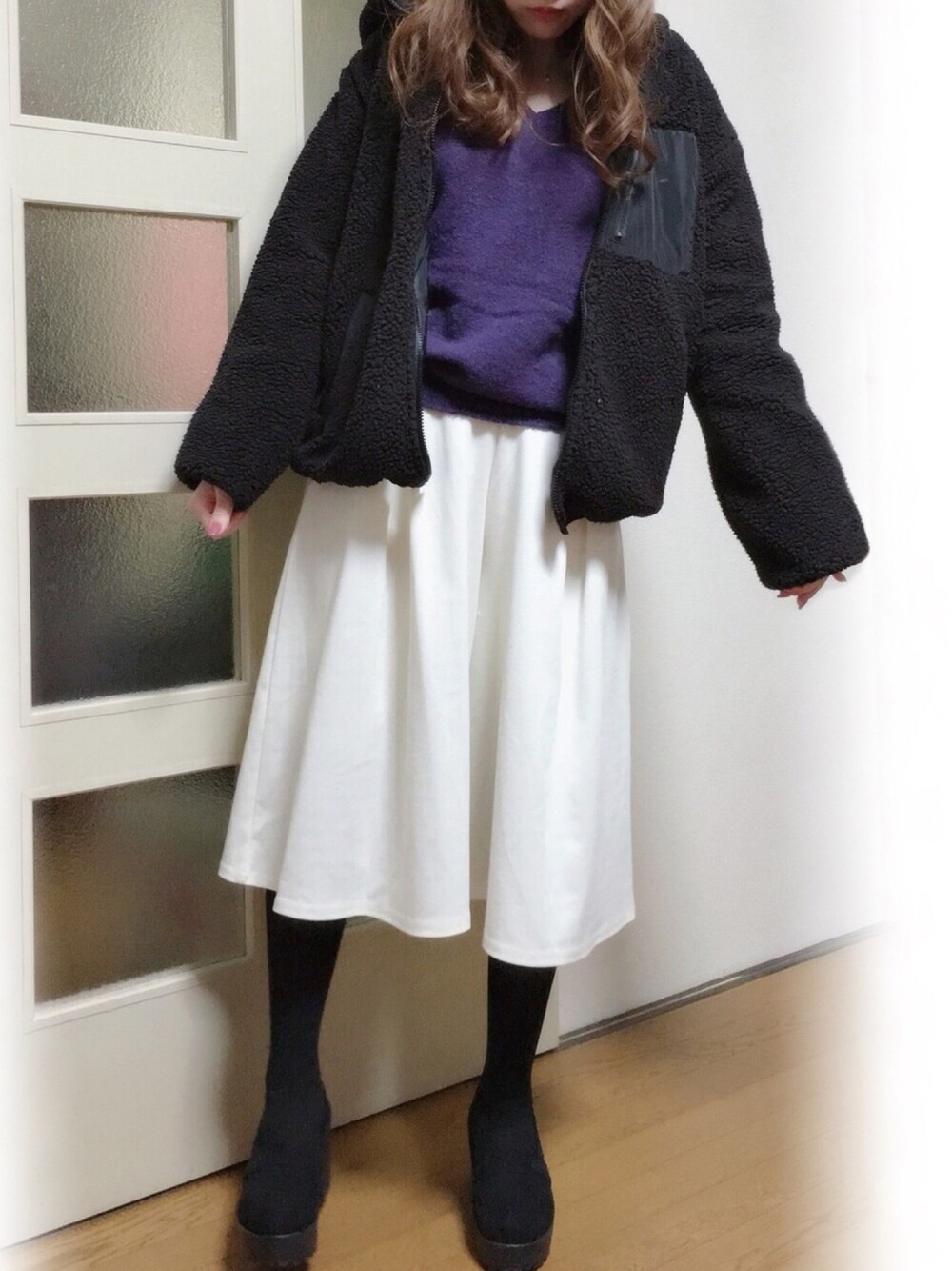 ブラック系のブルゾン、ブルー系のニット/セーター、ホワイト系のパンツを着用したレディースの冬コーディネートの1枚目の写真
