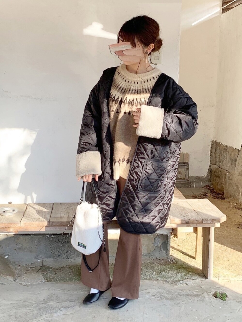 ブラック系のその他アウター、ベージュ系のニット/セーター、ブラウン系のパンツを着用したレディースの冬コーディネートの1枚目の写真