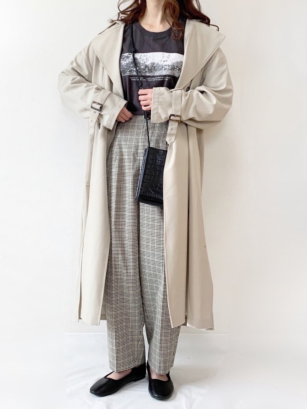 ベージュ系のトレンチコート、グレー系のTシャツ/カットソー、グレー系のパンツを着用したレディースの春コーディネートの1枚目の写真