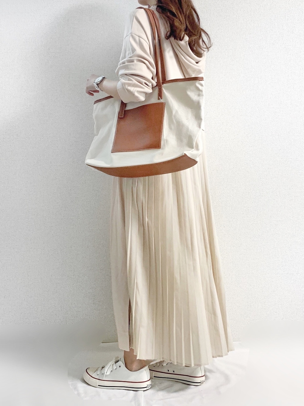 ベージュ系のワンピース、ブラウン系のトートバッグ、ホワイト系のアナログ腕時計を着用したレディースの夏コーディネートの1枚目の写真