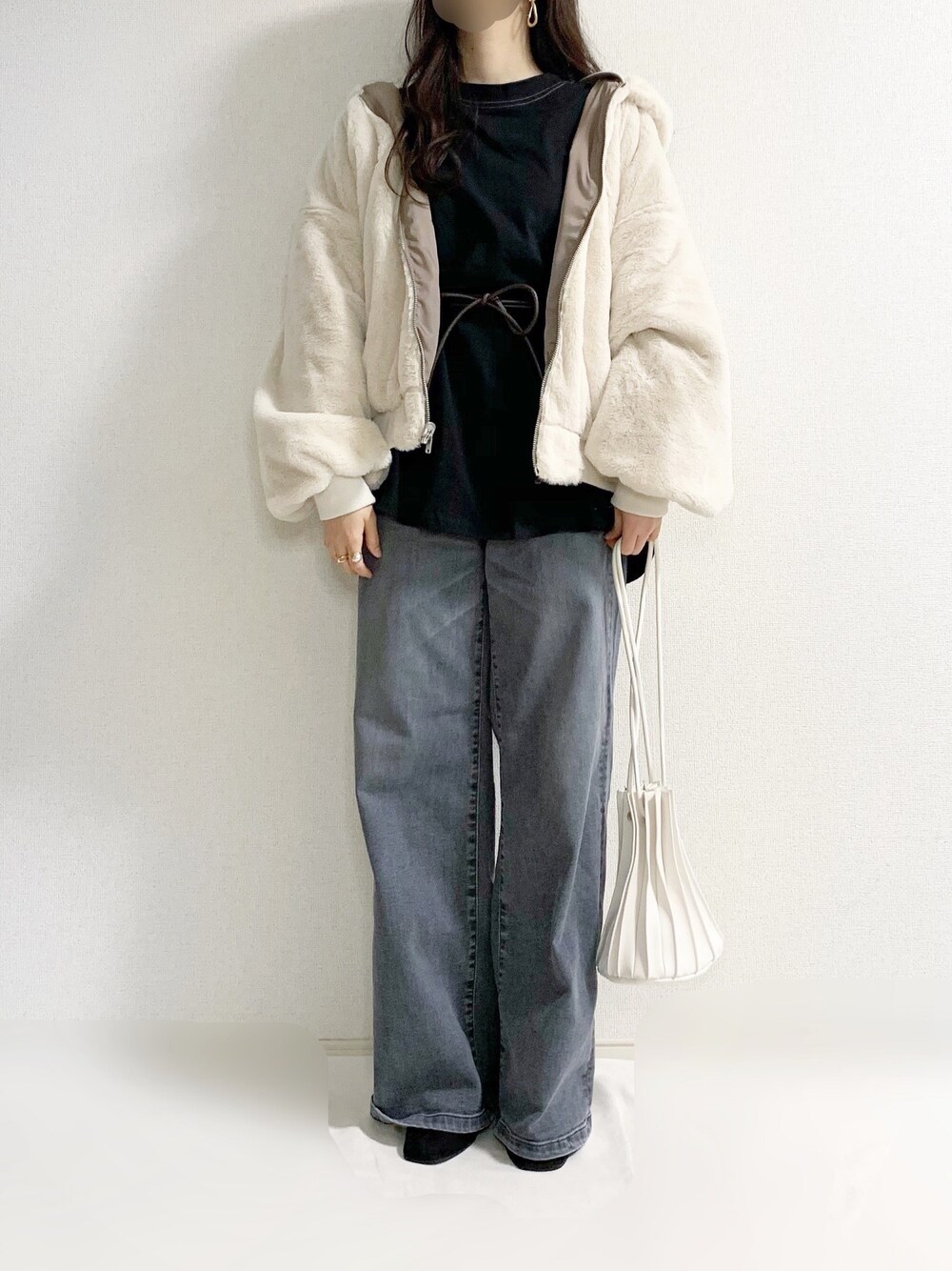 ベージュ系のブルゾン、ブラック系のTシャツ/カットソー、グレー系のデニムパンツを着用したレディースの冬コーディネートの1枚目の写真