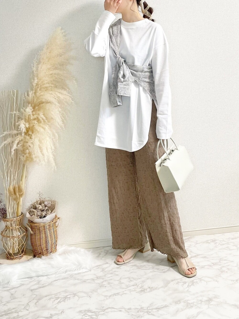 ホワイト系のTシャツ/カットソー、ブラウン系のパンツを着用したレディースの春コーディネートの1枚目の写真