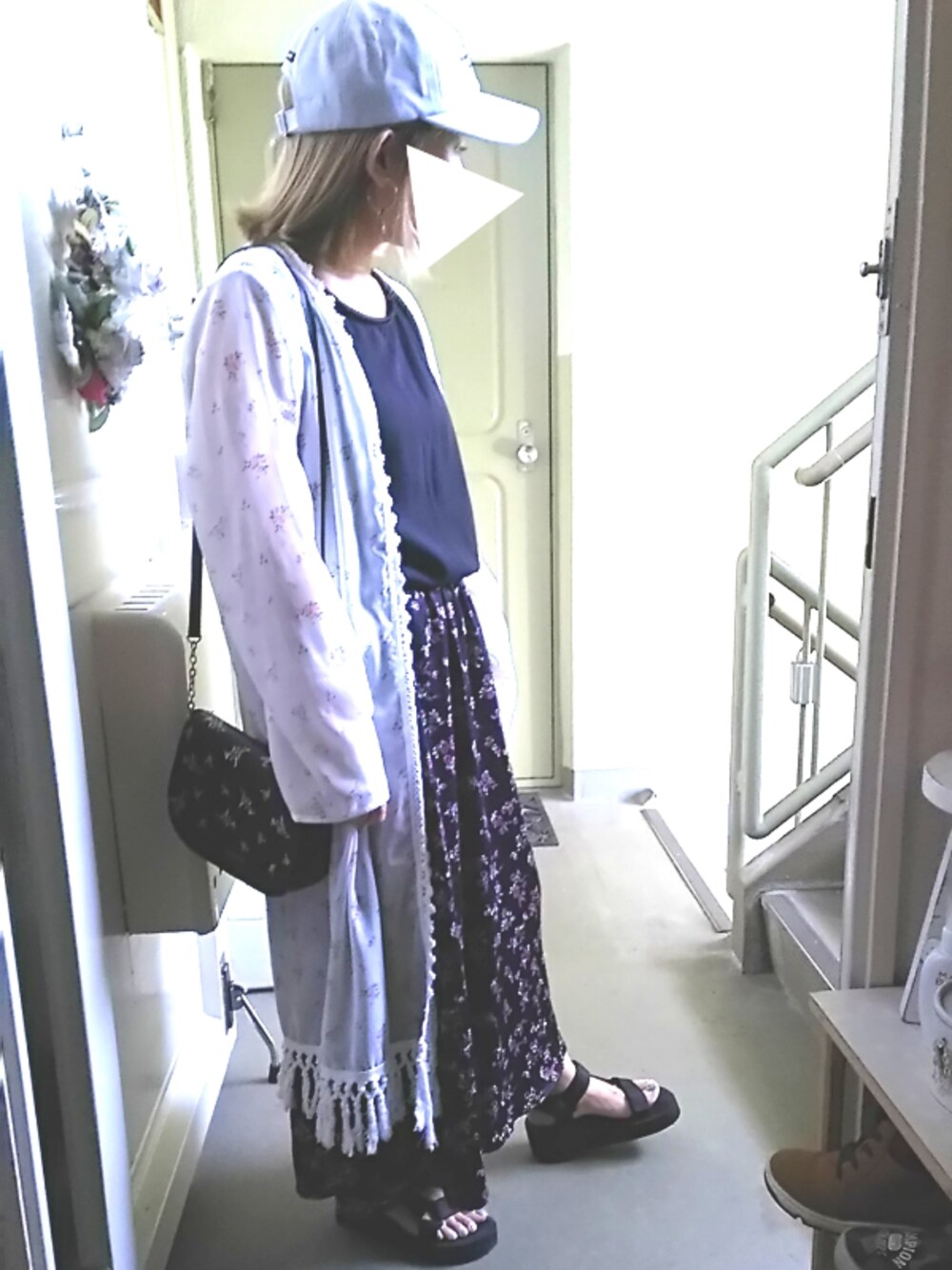 ブラック系のサンダル、ブラック系のスカート、ブラック系のショルダーバッグを着用したレディースの春コーディネートの1枚目の写真