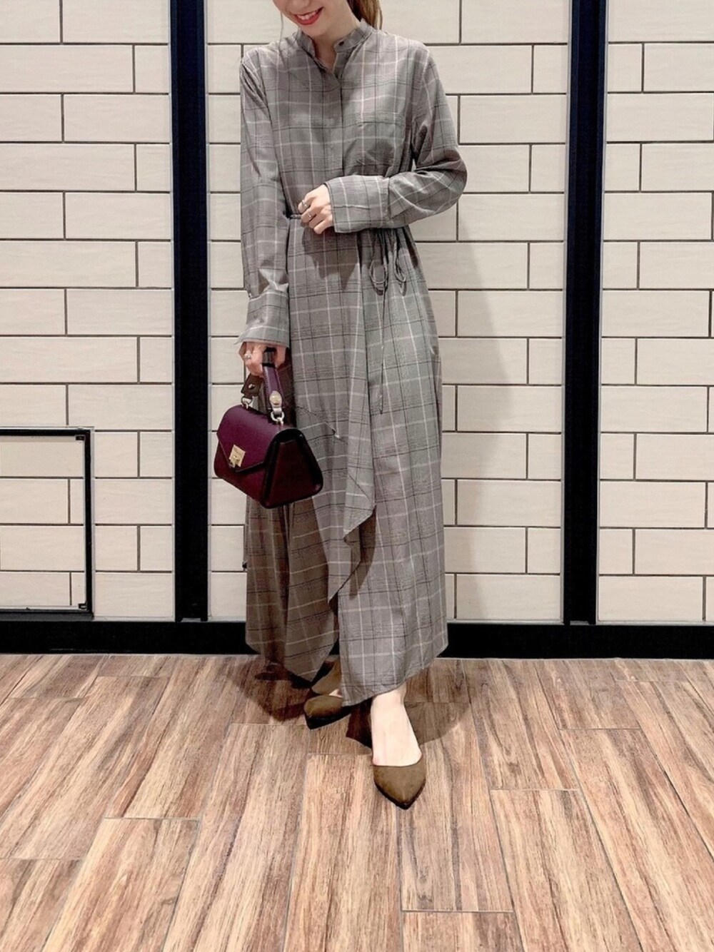 パープル系のショルダーバッグ、ブラウン系のパンプス、ブラック系のワンピースを着用したレディースの夏コーディネートの1枚目の写真