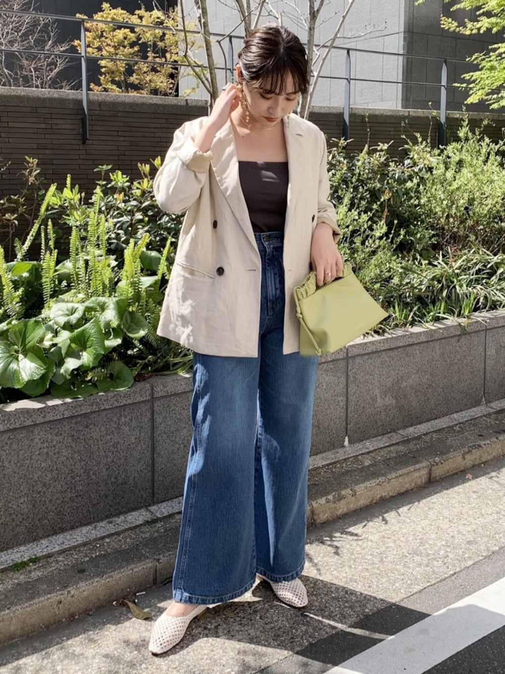 ホワイト系のテーラードジャケット、グレー系のキャミソール、グリーン系のバッグを着用したレディースの春コーディネートの1枚目の写真