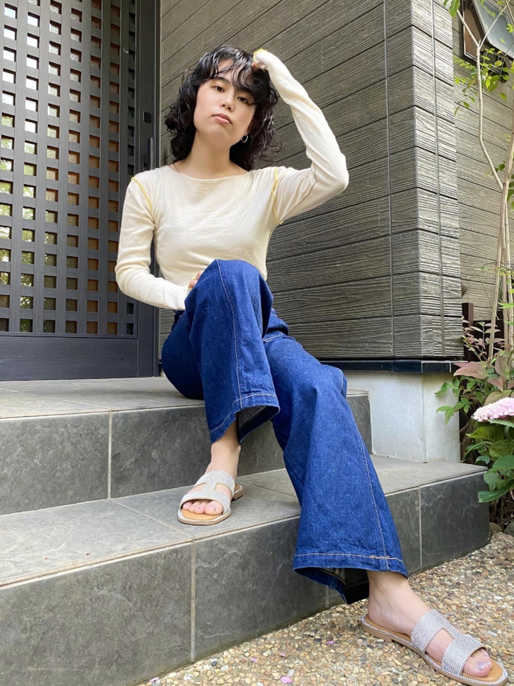 ブルー系のデニムパンツ、シルバー系のサンダル、ホワイト系のトップスを着用したレディースの春コーディネートの1枚目の写真