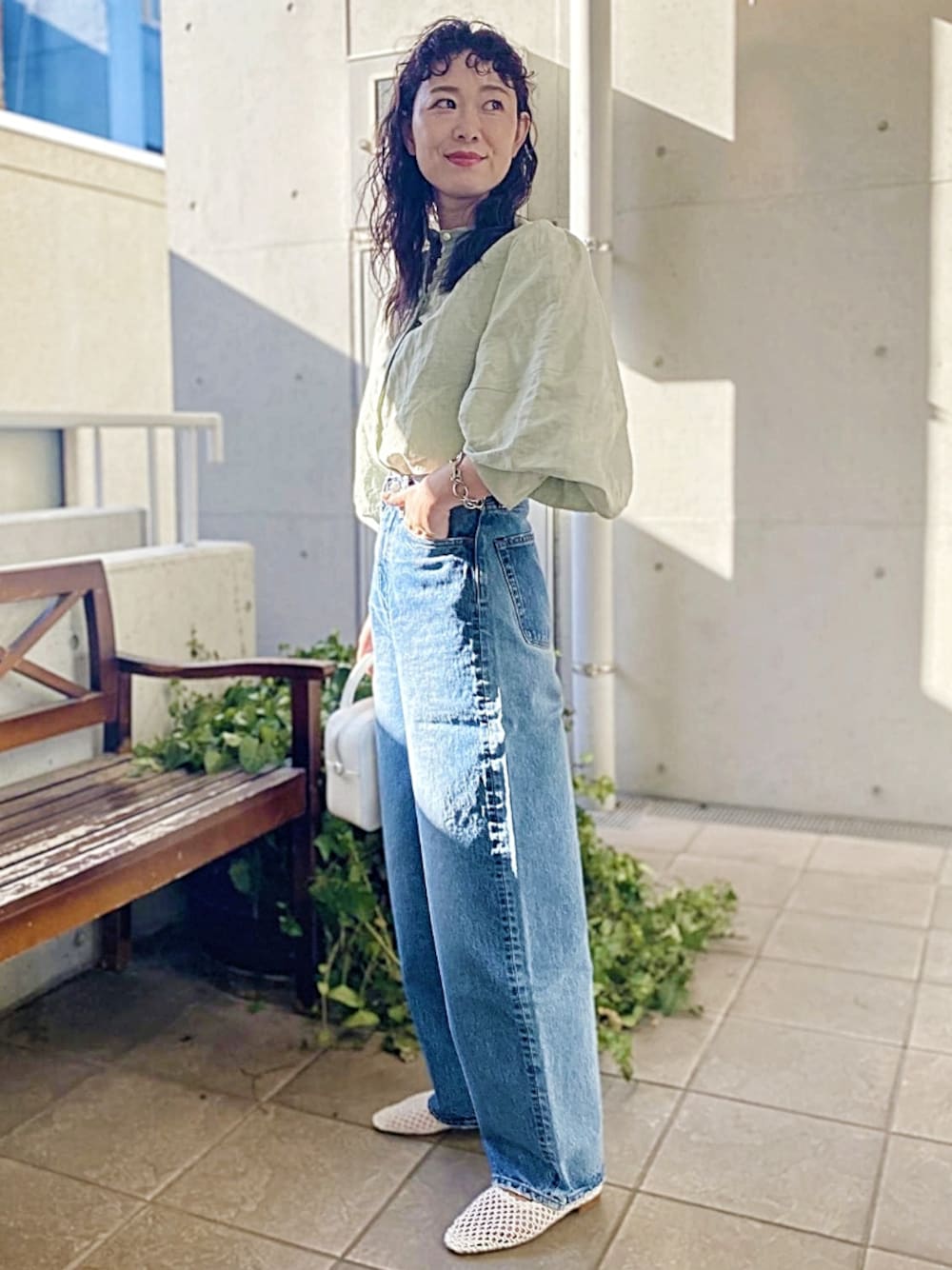 グリーン系のシャツ/ブラウス、ブルー系のデニムパンツ、ホワイト系のハンドバッグを着用したレディースの春コーディネートの1枚目の写真