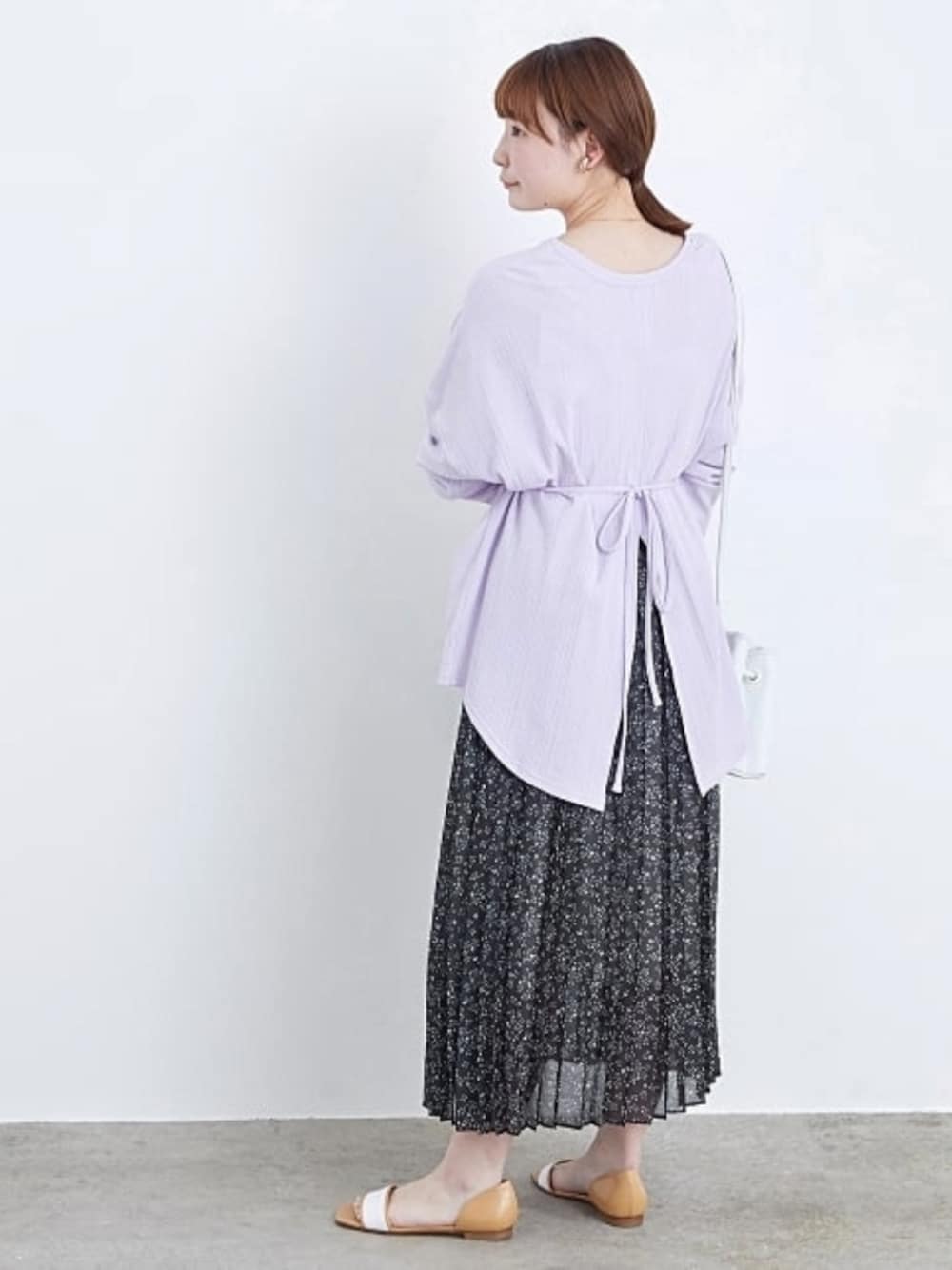 パープル系のTシャツ/カットソー、ブラック系のスカート、ブラウン系のシューズを着用したレディースの春コーディネートの1枚目の写真