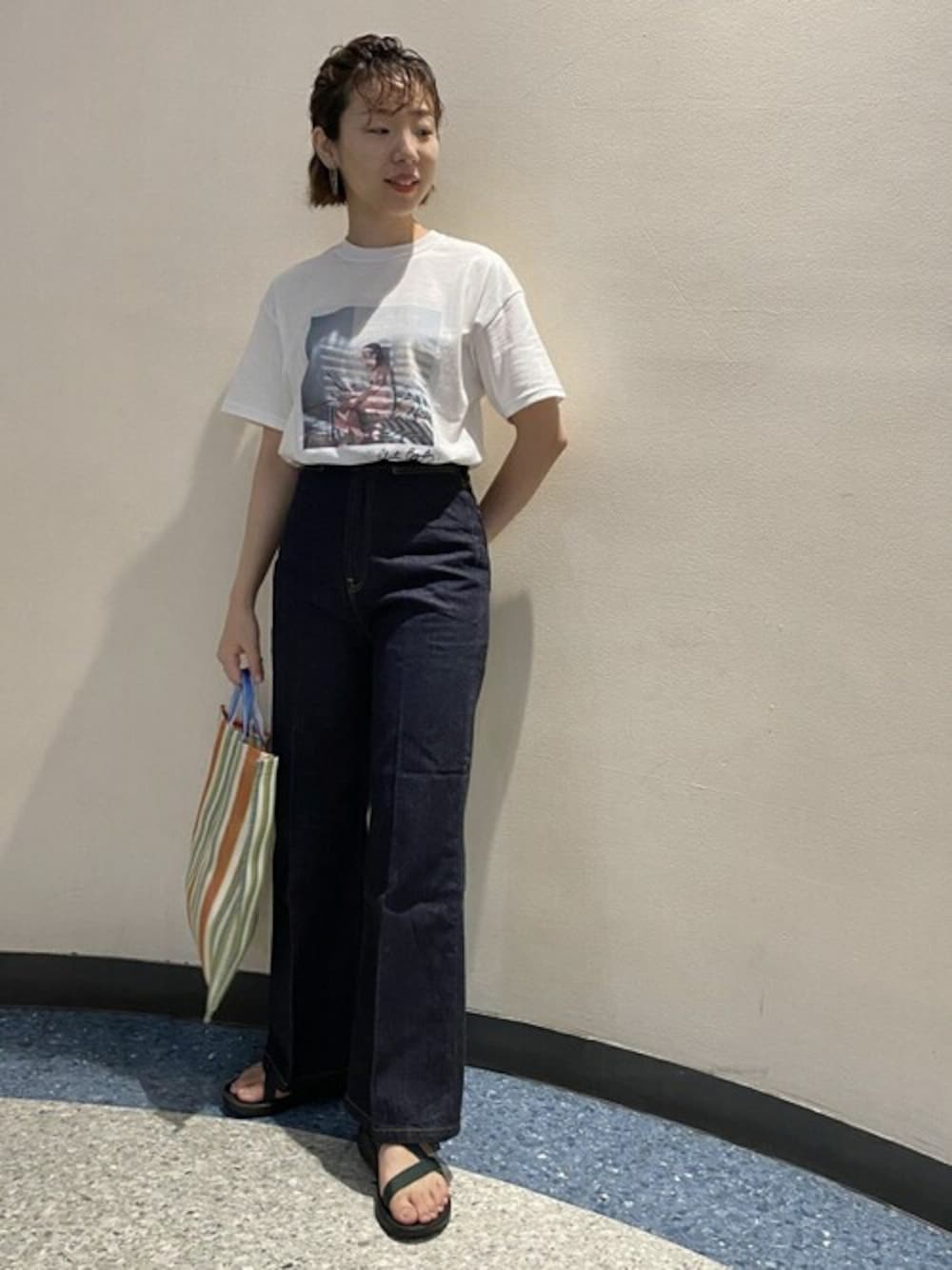 ホワイト系のTシャツ/カットソー、ブルー系のデニムパンツ、ブラウン系のトートバッグを着用したレディースの夏コーディネートの1枚目の写真