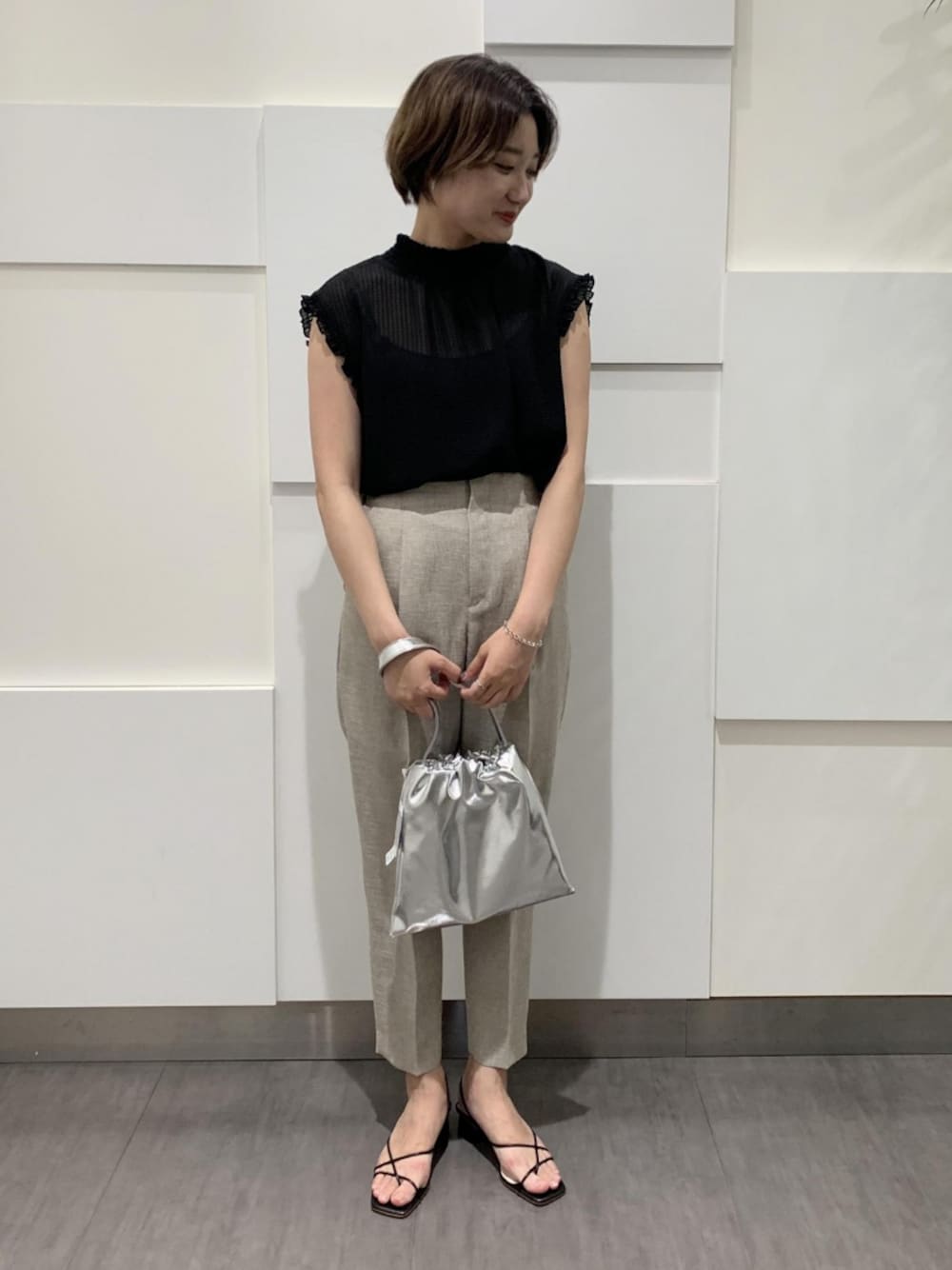 ブラック系のシャツ/ブラウス、ベージュ系のその他パンツ、シルバー系のバッグを着用したレディースの夏コーディネートの1枚目の写真