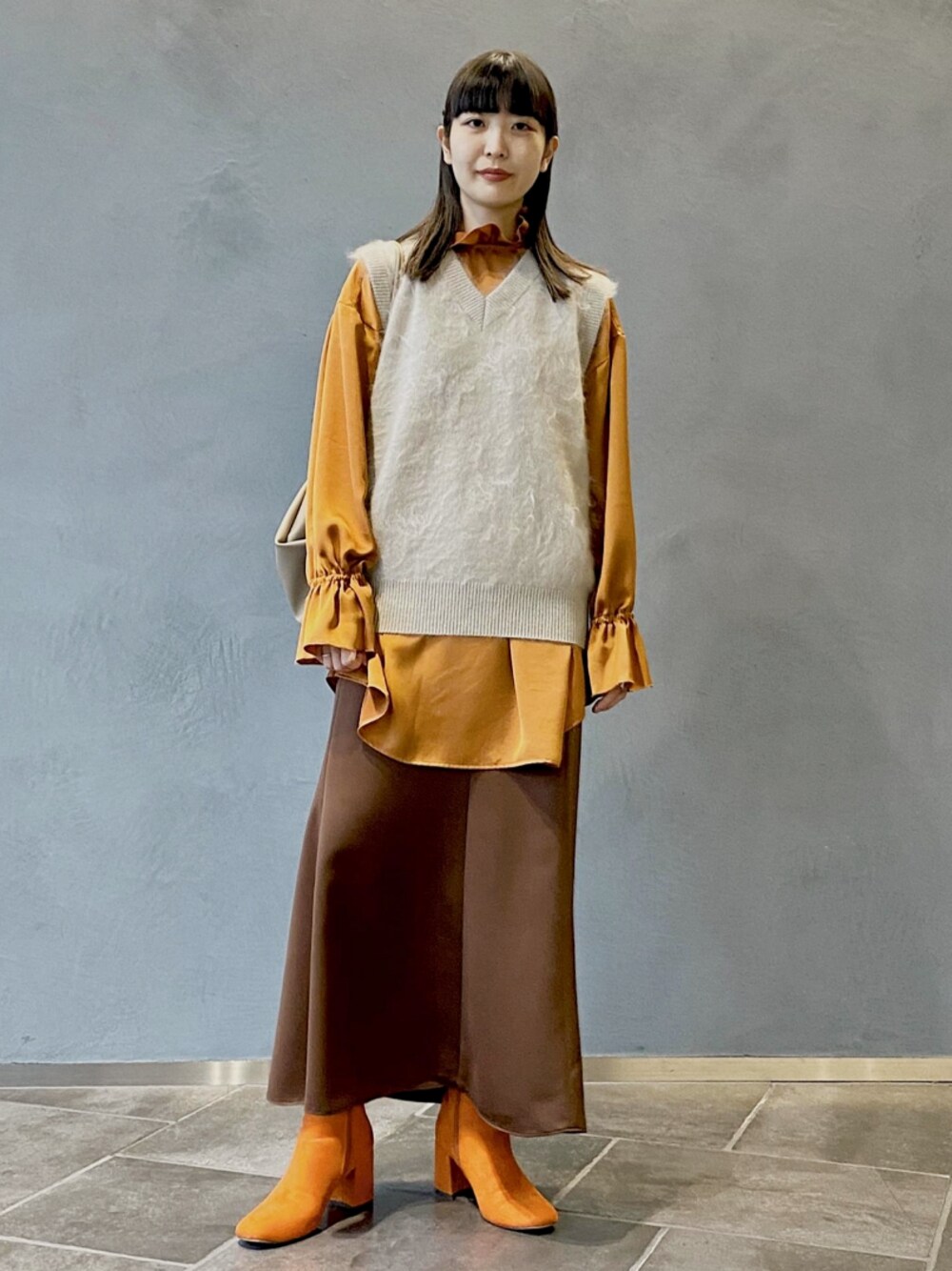 ブラウン系のシャツ/ブラウス、ブラウン系のスカート、ベージュ系のショルダーバッグを着用したレディースの秋コーディネートの1枚目の写真