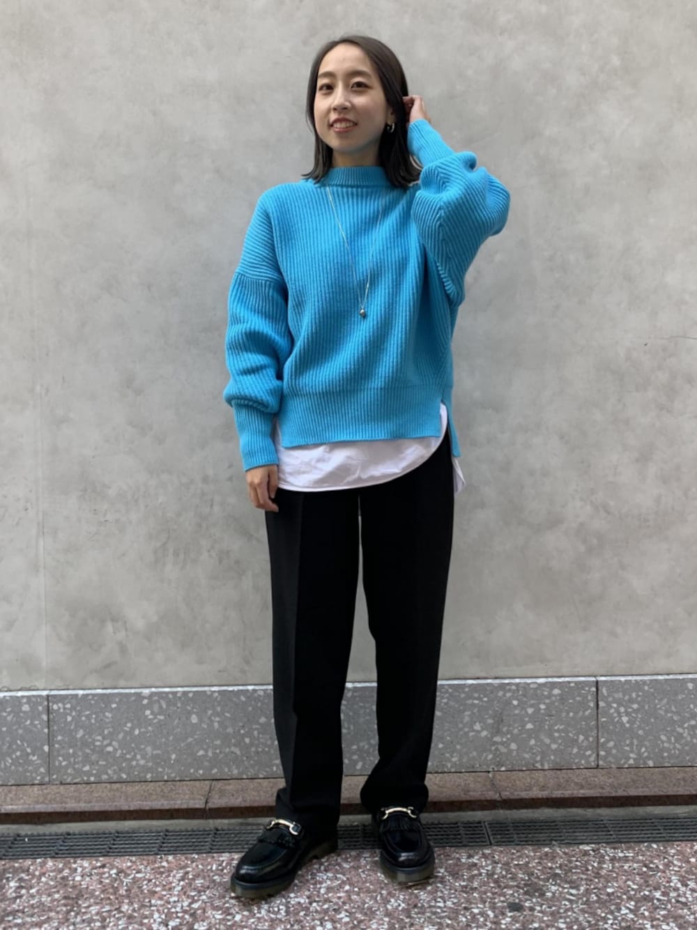 ブルー系のニット/セーター、ホワイト系のTシャツ/カットソー、ブラック系のローファーを着用したレディースの冬コーディネートの1枚目の写真