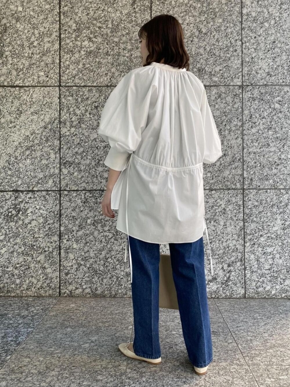 ベージュ系のバレエシューズ、ホワイト系のシャツ/ブラウス、ブルー系のデニムパンツを着用したレディースの冬コーディネートの1枚目の写真