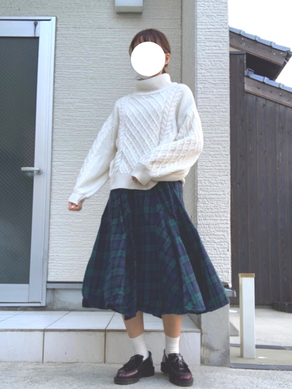 ホワイト系のニット/セーター、グリーン系のスカート、ブラウン系のシューズを着用したレディースの春コーディネートの1枚目の写真