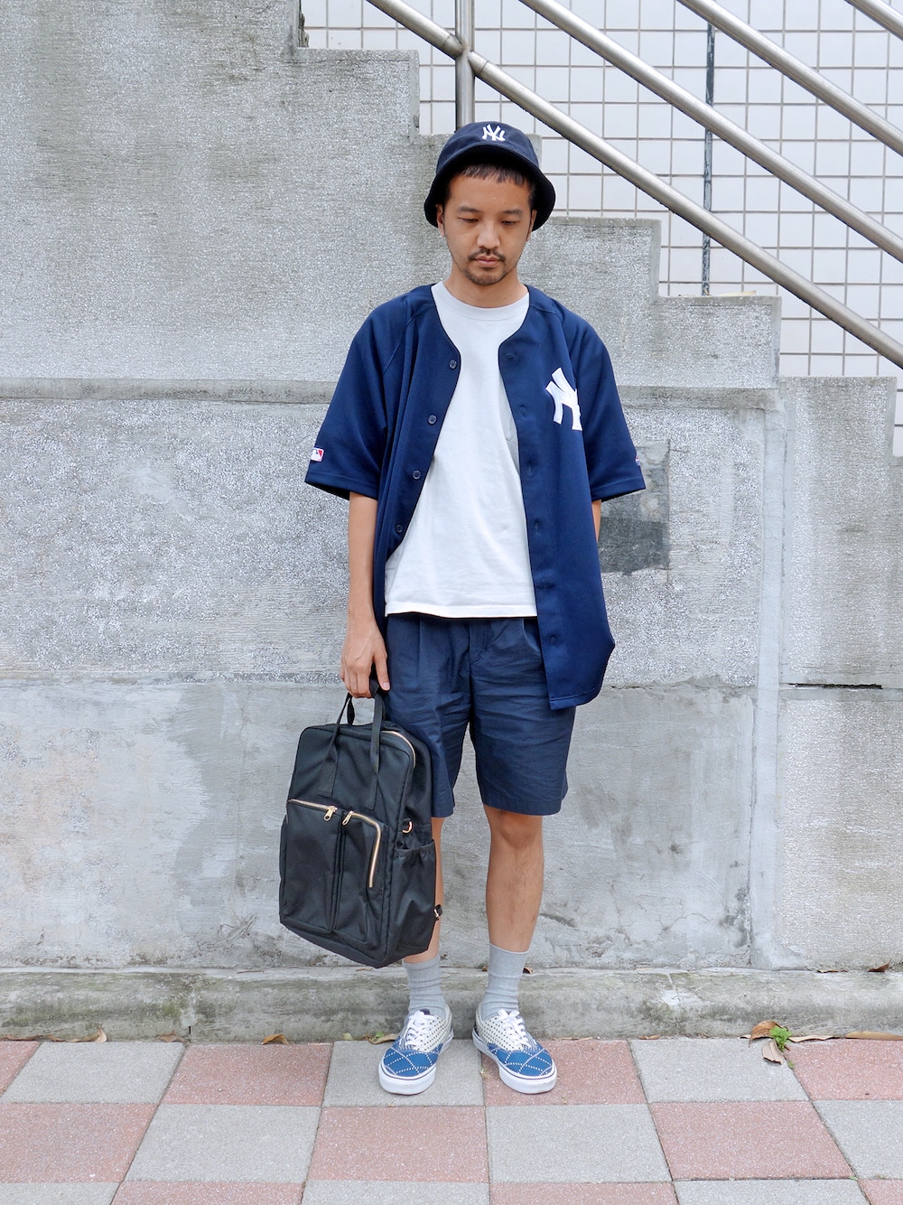 ブラウン系のクラッチバッグを着用したメンズの夏コーディネートの1枚目の写真