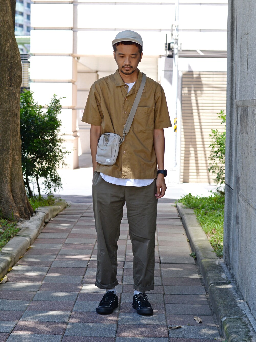 ホワイト系のTシャツ/カットソー、ブラック系のチノパンツ、ブルー系のショルダーバッグを着用したメンズの夏コーディネートの1枚目の写真