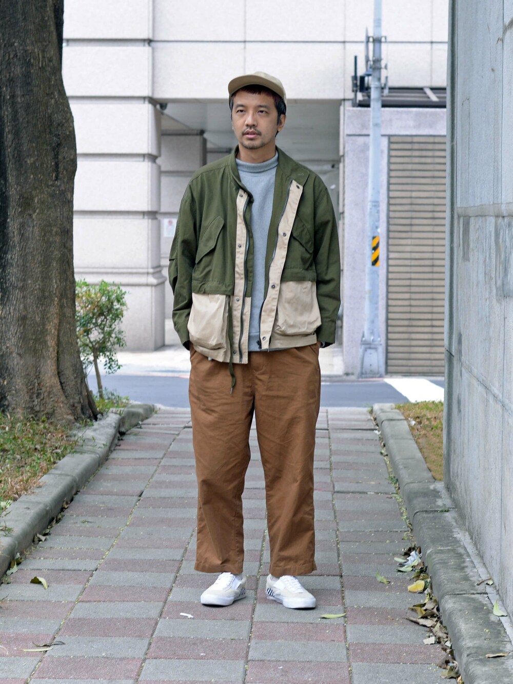 グレー系のTシャツ/カットソー、ブラウン系のスラックス、グリーン系のカバーオールを着用したメンズの秋コーディネートの1枚目の写真