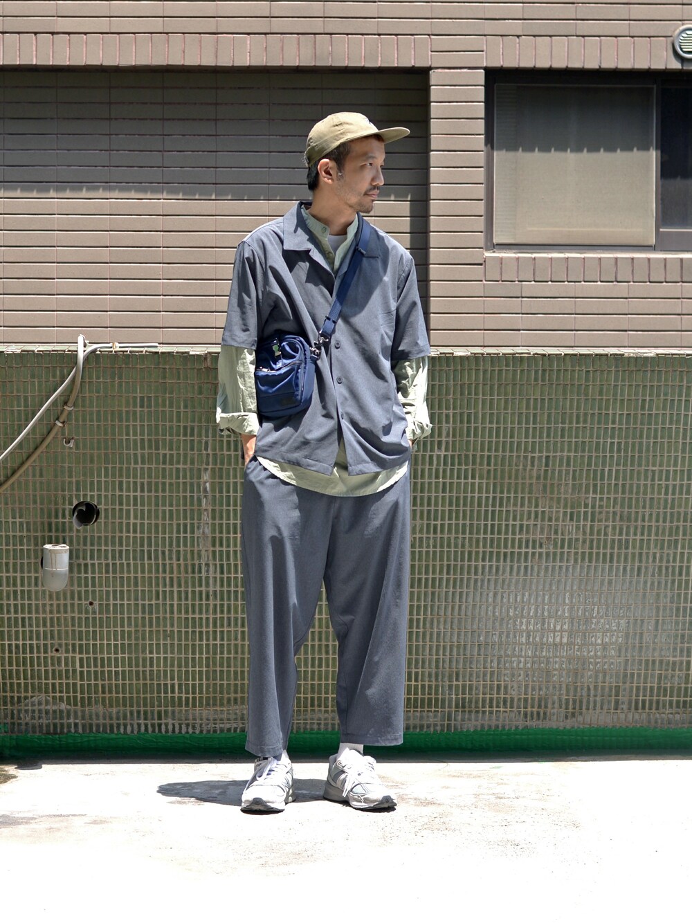 ブルー系のチノパンツ、グリーン系のシャツ/ブラウス、ベージュ系のキャップを着用したメンズの春コーディネートの1枚目の写真