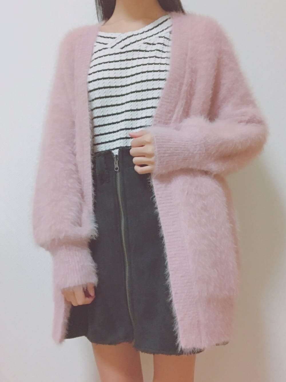 ブラック系のスカート、ホワイト系のTシャツ/カットソー、ピンク系のカーディガン/ボレロを着用したレディースの秋コーディネートの1枚目の写真