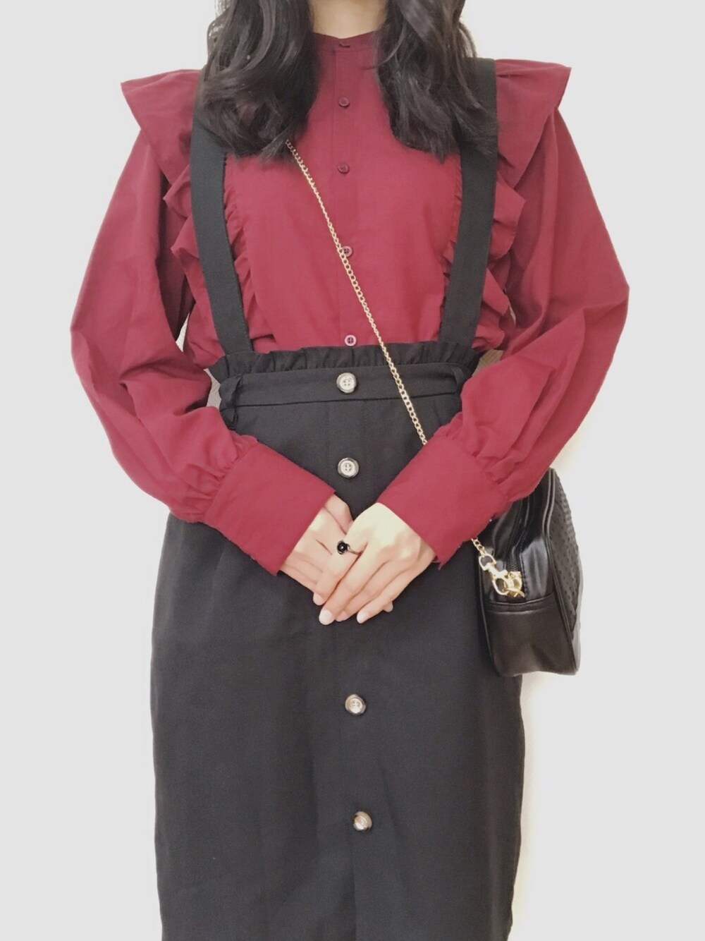 ブラック系のサロペット/オーバーオール、ブラック系のショルダーバッグ、レッド系のシャツ/ブラウスを着用したレディースの冬コーディネートの1枚目の写真