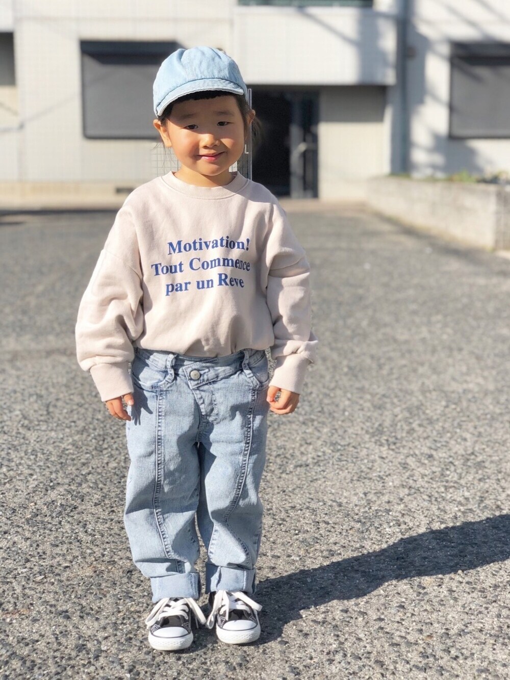 ベージュ系のスウェット、ブルー系のデニムパンツ、ブラック系のスニーカーを着用したキッズの冬コーディネートの1枚目の写真