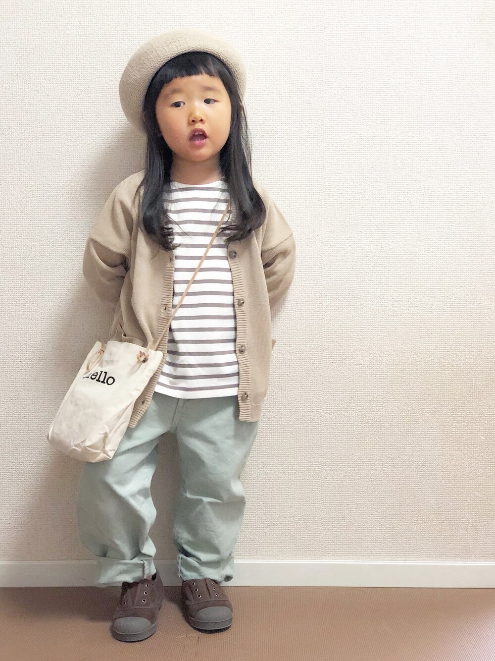ベージュ系のTシャツ/カットソー、ベージュ系のカーディガン/ボレロ、グリーン系のデニムパンツを着用したキッズの春コーディネートの1枚目の写真