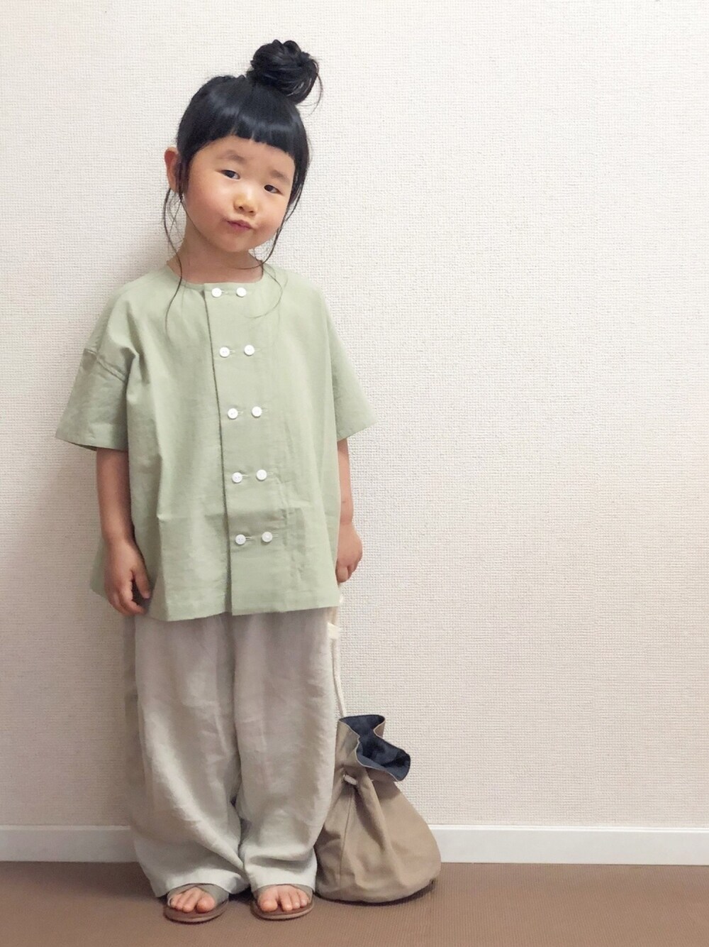 グリーン系のシャツ/ブラウス、ホワイト系のその他パンツ、ベージュ系のショルダーバッグを着用したキッズの春コーディネートの1枚目の写真
