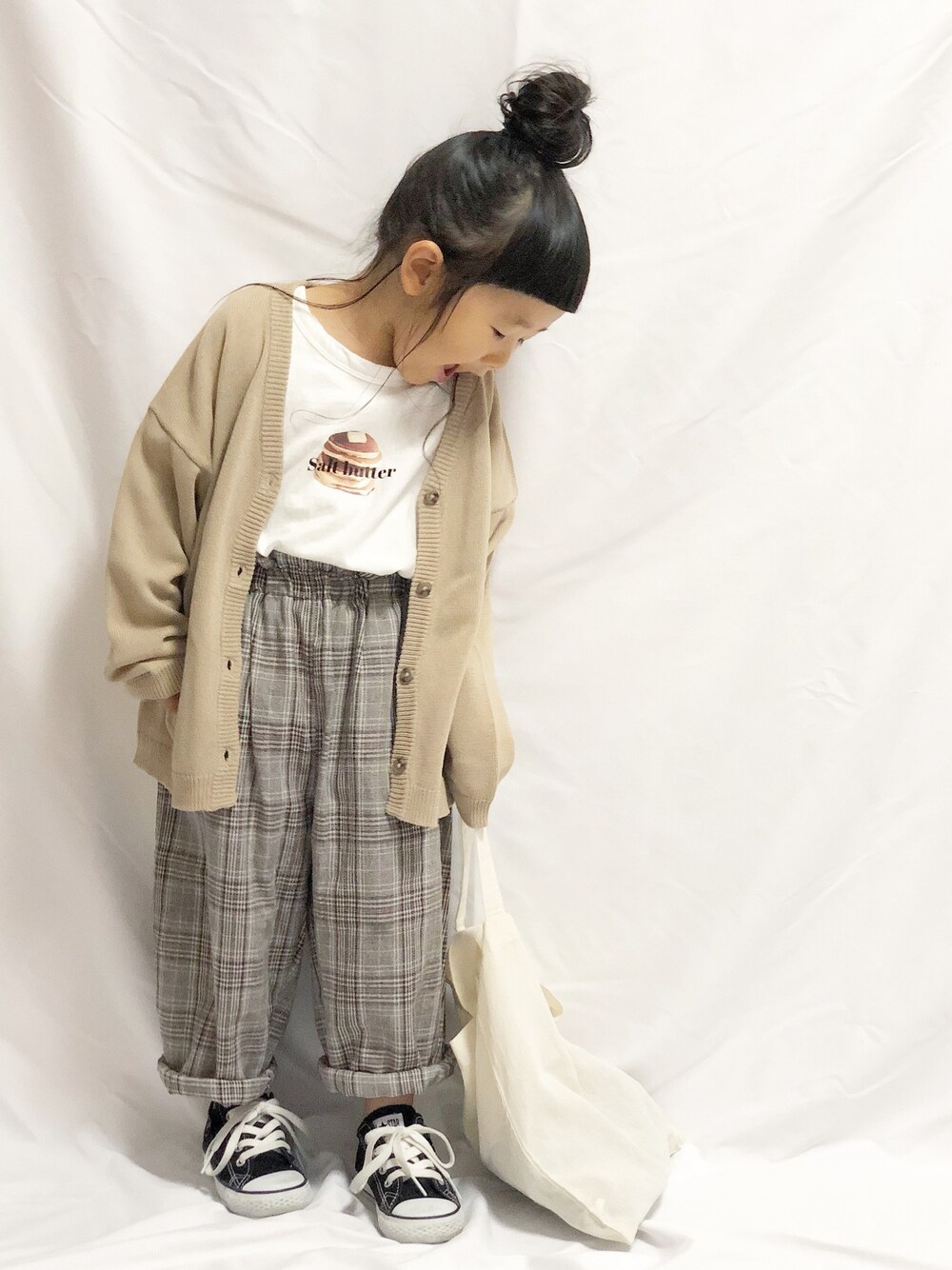 ホワイト系のTシャツ/カットソー、ベージュ系のカーディガン/ボレロ、ブラウン系のパンツを着用したキッズの春コーディネートの1枚目の写真