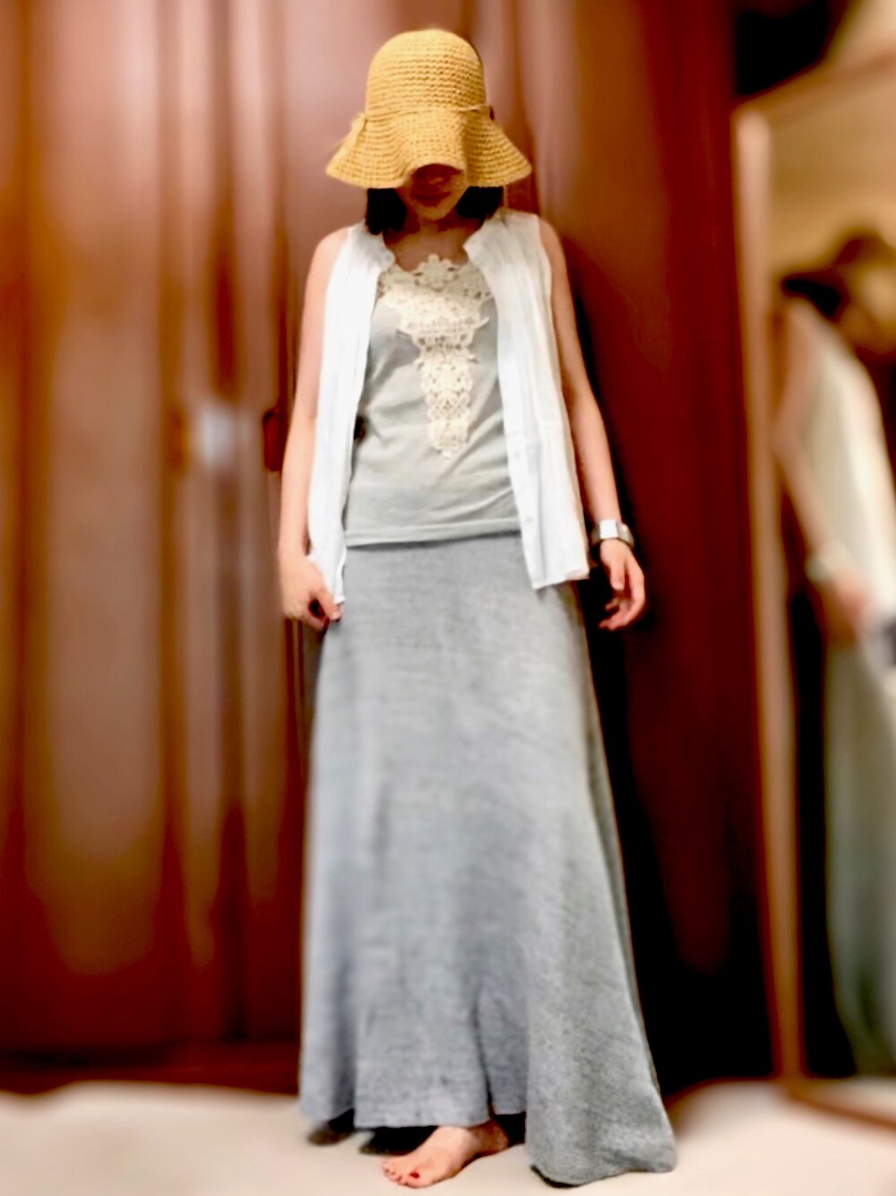 グレー系のスカート、ホワイト系のサンダル、グレー系のタンクトップを着用したレディースの夏コーディネートの1枚目の写真