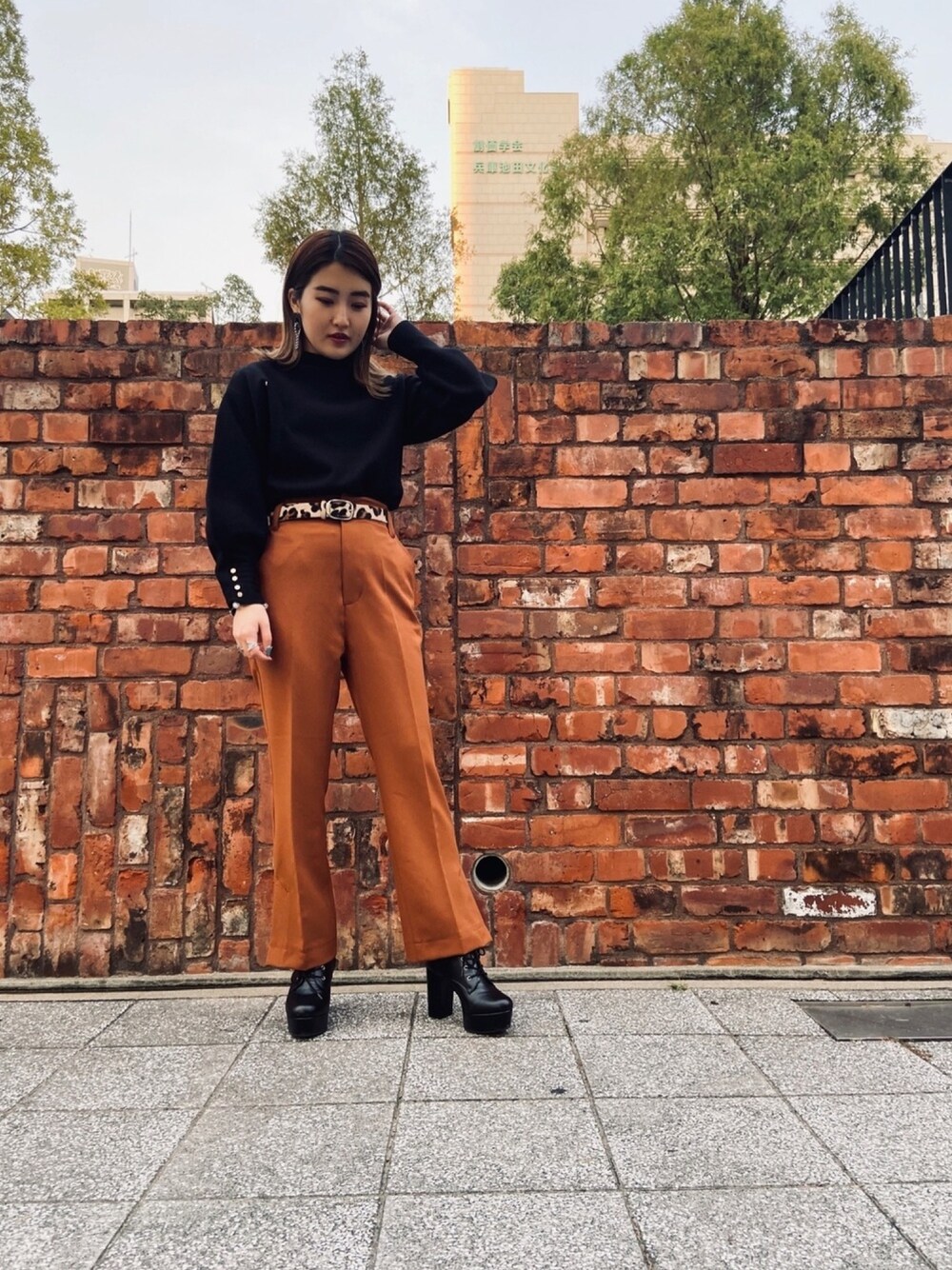 ブラック系のニット/セーター、ブラウン系のその他パンツ、その他のベルトを着用したレディースの秋コーディネートの1枚目の写真