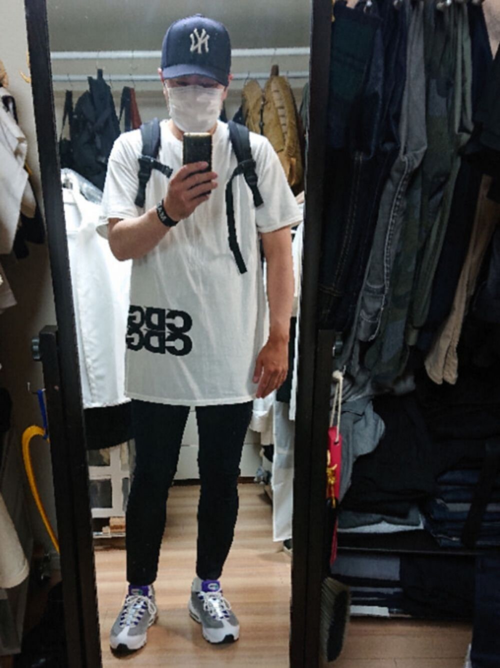 ブラック系のバックパック/リュック、ホワイト系のスニーカー、ホワイト系のTシャツ/カットソーを着用したメンズの春コーディネートの1枚目の写真