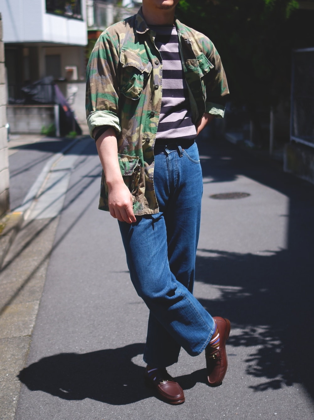 ブラウン系のローファー、ブルー系のデニムパンツ、ブラック系のTシャツ/カットソーを着用したメンズの春コーディネートの1枚目の写真