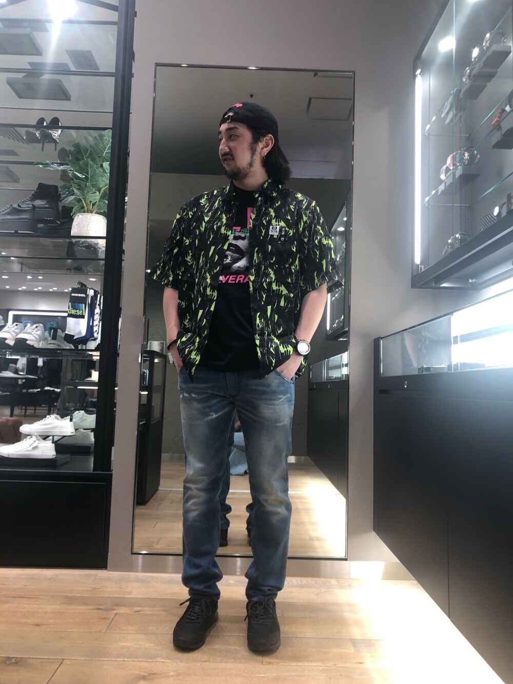 グリーン系のシャツ/ブラウス、ブラック系のTシャツ/カットソー、ブルー系のデニムパンツを着用したメンズの春コーディネートの1枚目の写真